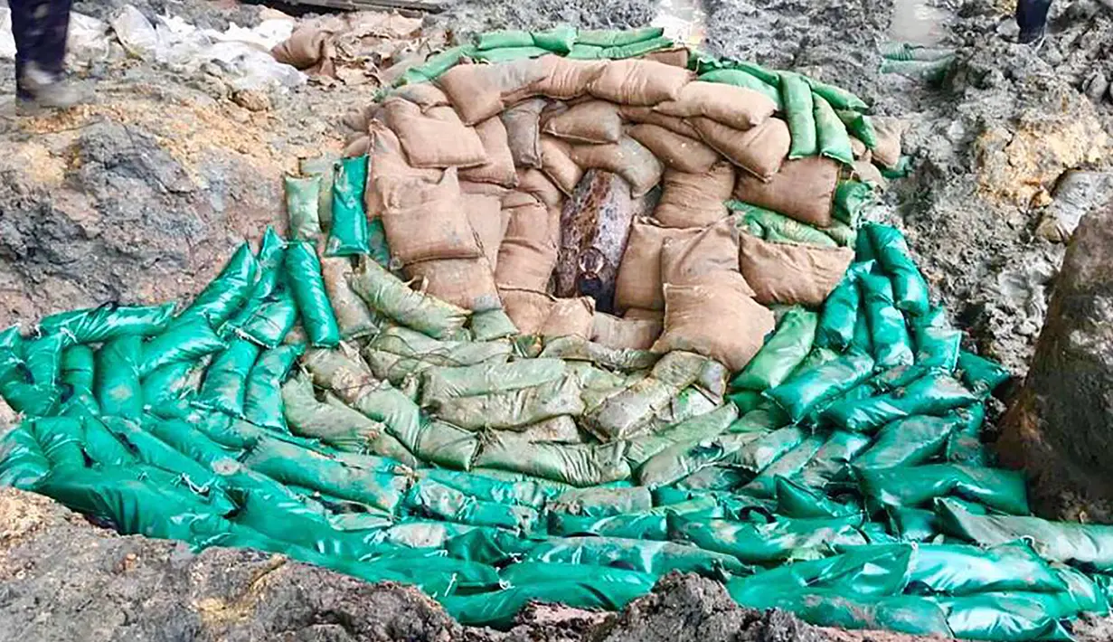 Sejumlah karung pasir ditumpuk untuk mengamankan bom buatan AS yang dijatuhkan pada Perang Dunia II di persimpangan Convention Avenue dan Hung Hing Road di distrik Wan Chai di Hong Kong (11/5). (Handout / Polisi Hong Kong / AFP)