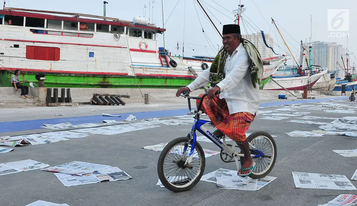 Umat muslim bersepeda usai menjalankan Salat Idul Adha 1438 H di kawasan Pelabuhan Sunda Kelapa, Jakarta, Jumat (1/9). Setelah menjalankan salat, umat muslim melakukan penyembelihan hewan kurban. (Liputan6.com/Helmi Afandi)