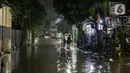 Warga melintas di genangan banjir di kawasan Mampang Prapatan, Jakarta, Sabtu (13/11/2021). Intensitas hujan yang tinggi sejak sore di Jakarta membuat kawasan permukiman di Mampang Prapatan tergenang banjir dengan tinggi sebetis orang dewasa. (Liputan6.com/Faizal Fanani)