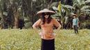 Pemilik nama lengkap Gita Sari Sonya Sinaga memang sosok yang sederhana. Ia tak merasa gengsi saat melakukan kegiatan yang membuat dia merasa kepanasan. Seperti saat Gita pergi ke kebun dengan penampilan simpel berkaus dan pakai caping. (Liputan6.com/IG/gitasinaga)