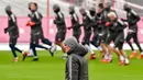 Pelatih Bayern Munchen, Jupp Heynckes (kiri) melihat para pemainnya saat latihan jelang melawan PSG di Liga Champions di Munich, Jerman, (4/12). Pada pertemuan pertama Munchen takluk 3-0 atas PSG. (AFP Photo/Guenter Schiffmann)