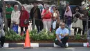 Sejumlah warga berdiri di sisi jalan TMP Kalibata untuk melihat prosesi pemakaman Presiden RI ke-3 BJ Habibie, Jakarta, Kamis (12/9/2019). BJ Habibie meninggal dunia pada Rabu (11/9/2019) pukul 18.05 WIB di usia 83 tahun. (Liputan6.com/Helmi Fithriansyah)
