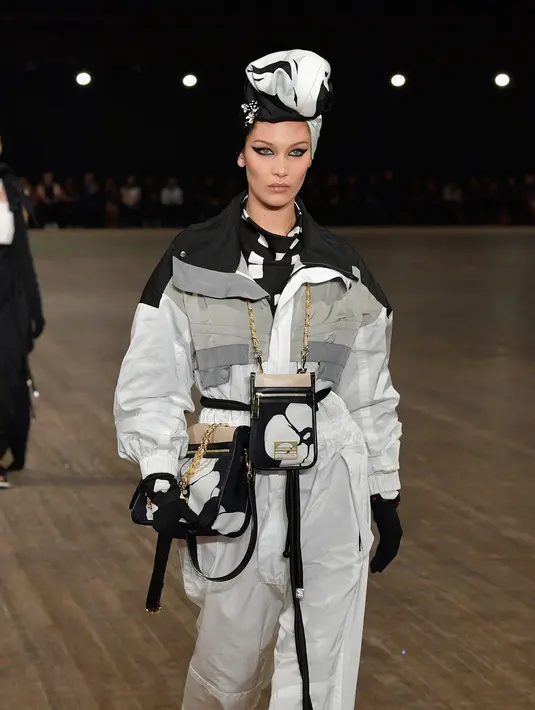 Model cantik, Bella Hadid berjalan di catwalk dalam balutan koleksi Marc Jacobs Spring/Summer 2018 selama New York Fashion Week, Rabu (13/9). Bella tampil sporty memakai jaket warna hitam putih dengan turban warna senada. (SLAVEN VLASIC/GETTY IMAGES/AFP)