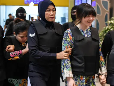 Tersangka kasus pembunuhan Kim Jong-nam, Siti Aisyah dan Doan Thi Huong, dikawal polisi menuju Bandara Internasional Kuala Lumpur, Selasa (24/10). Keduanya melakukan reka ulang kejadian di tempat keduanya dituding meracuni Kim Jong-nam. (MOHD RASFAN/AFP)