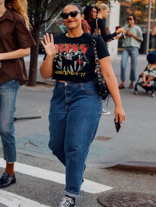 Kaus grafis bernuansa vintage juga bisa menjadi pilihan terbaik untuk menghadirkan kesan kasual dengan baggy jeans. Kamu bisa memotong atau mengikat kaus ini sesuai gayamu sendiri. Foto: instyle.com.