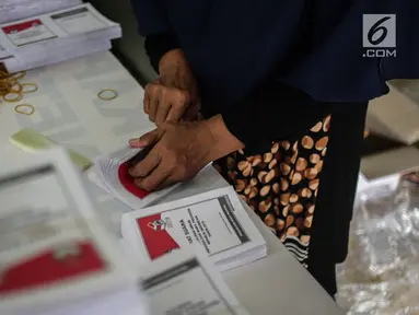 Seorang pekerja menyelesaikan pelipatan surat suara Pemilihan Umum 2019 di gudang logistik KPU Jakarta Pusat, Selasa (19/2). Proses pelipatan surat suara diiikuti 62 orang yang direkrut dari wilayah sekitar gudang KPU. (Liputan6.com/Faizal Fanani)