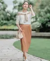 Tampilan feminin yang stylish, padukan long sleeve dengan satin flare skirt warna peach. Makin stylish dengan cardigan yang diikat di pundak. (Instagram/jscmila).