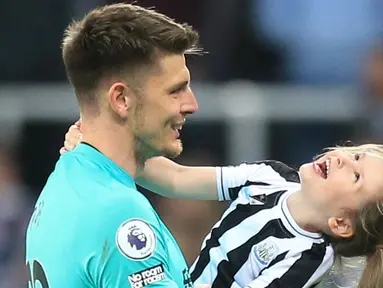 Kiper Newcastle United, Nick Pope, bercanda dengan anaknya setelah laga melawan Leicester City pada pekan ke-37 Premier League 2022-2023, Selasa (23/5/2023). Hasil imbang melawan Leicester membawa The Magpies lolos ke Liga Champions musim depan. (AFP/Lindsey Parnaby)