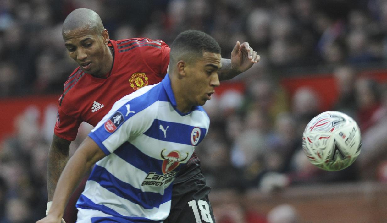 Bek Manchester United, Ashley Young, berebut  bola dengan pemain Reading, Andy Rinomhota, pada laga Piala FA di Stadion Old Trafford, Sabtu (5/1). Manchester United menang 2-0 atas Reading. (AP/Rui Vieira)