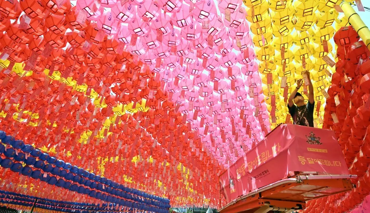 <p>Para pekerja memasang lentera teratai di Kuil Jogyesa, Seoul, Korea Selatan, Jumat (26/5/2023). Pemasangan lentera dilakukan jelang perayaan ulang tahun Buddha pada 27 Mei. (Jung Yeon-je/AFP)</p>