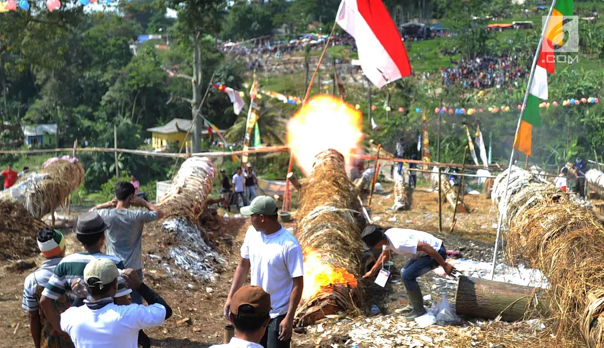 Warga menyalakan meriam karbit selama kegiatan Pesta Rakyat Sukamakmur di Desa Sukamakmur, Bogor, Minggu (16/6/2019). Kegiatan berupa perang meriam karbit yang terbuat dari batang pohon kapuk antar desa setelah perayaan lebaran ini terakhir diselenggarakan 13 tahun silam. (merdeka.com/Arie Basuki)