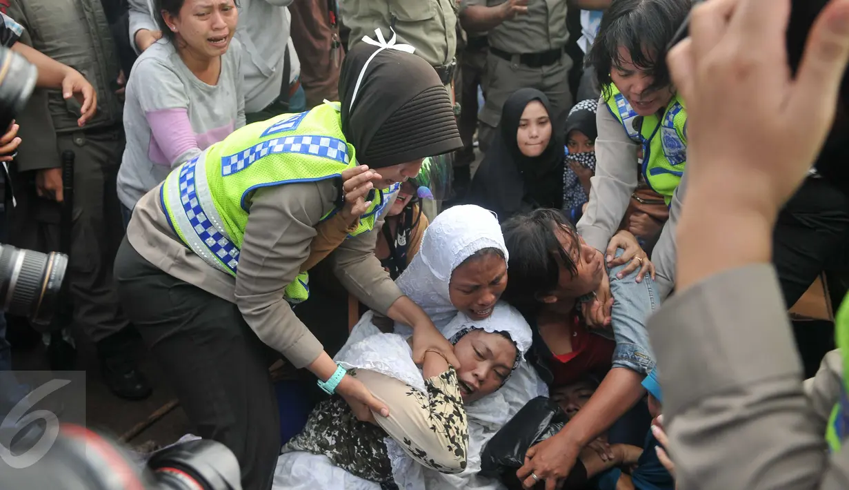 Sejumlah ibu-ibu histeris saat petugas berusaha membubarkan aksi mereka pada penggusuran di Pasar Ikan, Penjaringan, Jakarta, Senin (11/4). Warga yang didominasi perempuan itu ikut menolak penggusuran kawasan tersebut. (Liputan6.com/Gempur M Surya)
