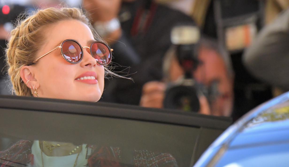 Aktris AS Amber Heard masuk ke dalam mobil saat tiba untuk menghadiri malam pembukaan Festival Film Cannes ke-72 di Prancis (13/5/2019). Mantan istri Johnny Depp ini tampil gaya dengan kaos putih, skinny jeans dan jaket multi-warna, dihiasi dengan jumbai berbulu.
(AFP Photo/Loic Venance)