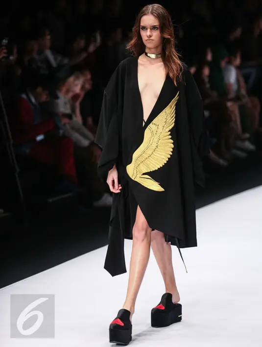 Seorang model mengenakan pakaian rancangan Oxcel yang bertemakan Muhammad Ali dalam Jakarta Fashion Week di Jakarta, Minggu (23/10). Oxcel menampilkan karyanya yang dominan berwarna hitam dengan elemen-elemen tinju. (Liputan6.com/Faizal Fanani)