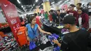 Pramuniaga melayani pengunjung yang membeli sepatu dalam Nike Bazaar di Mal Grand Indonesia, Jakarta, Rabu (23/8). Nike memberi diskon hingga mencapai 90 persen untuk semua produk sepatu lelaki dan perempuan. (Liputan6.com/Immanuel Antonius)