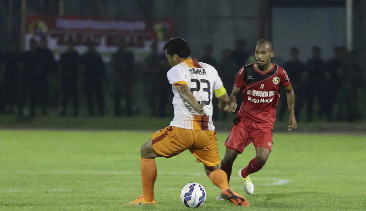 Striker Semen Padang, Nur Iskandar, melewati bek PBFC, Hamka Hamzah, pada laga semifinal Piala Jenderal Sudirman di Stadion Stadion Haji Agus Salim, Padang, Sabtu (16/1/2016). (Bola.com/Reza Bachtiar)