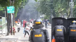 Pengunjuk rasa melemparkan batu ke arah petugas polisi selama bentrokan sebelum terjadi pembakaran bis milik Brimob di kawasan Tanah Abang,  Jakarta, Rabu (22/5/2019). (merdeka.com/Arie Basuki)