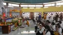 Umat Buddha mengikuti prosesi Puja Bakti di Wihara Arya Dwipa Arama, Taman Mini Indonesia Indah (TMII), Jakarta, Senin (12/5/2025). (Liputan6.com/Herman Zakharia)