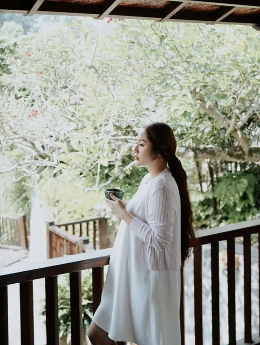 Siti Badriah tampil santai dengan mini dress putih dengan luaran cardigan putih. Dok. Instagram @sitibadriahh