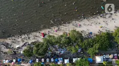 Foto udara memperlihatkan warga yang berwisata saat libur lebaran di Pantai Lagoon Taman Impian Ancol, Jakarta, Kamis (11/4/2024). (Liputan6.com/Herman Zakharia)