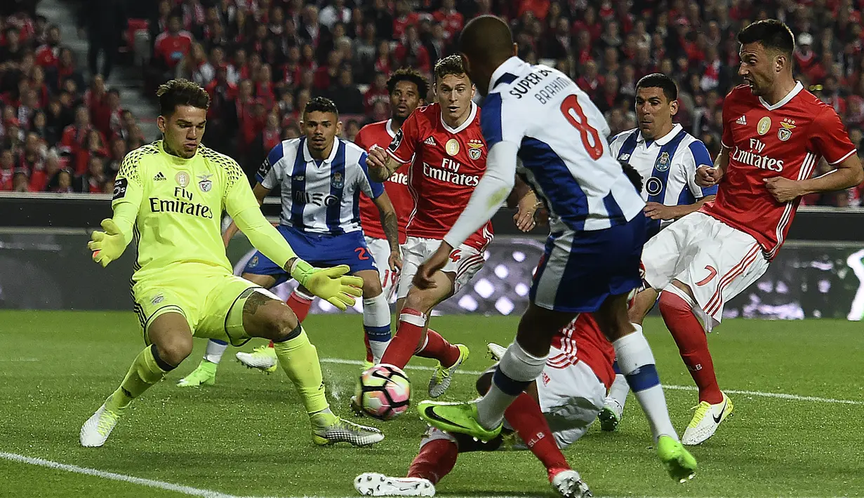 Kiper Benfica, Ederson Moraes, berusaha mengamankan bola dari gelandang Porto, Yacine Brahimi pada laga Liga Portugal di Stadion Luz, Lisbon, Sabtu (1/4/2017). (AFP/Francisco Leong)