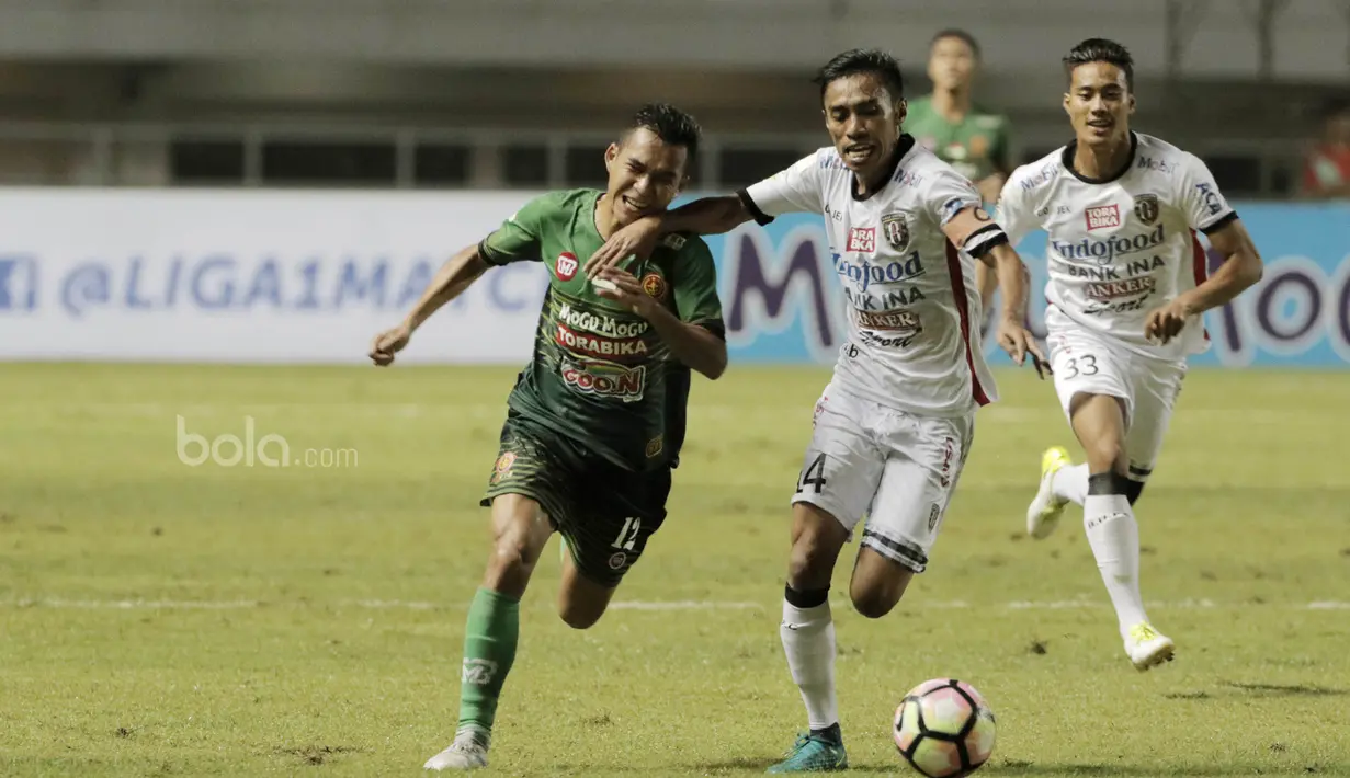 Kapten Bali United, Fadil, berebut bola dengan gelandang PS TNI, Erwin Ramdani pada laga lanjutan liga 1 di Stadion Pakansari, Bogor, Senin (10/7/2017). Bali United menang 4-3 atas PS TNI. (Bola.com/M Iqbal Ichsan)