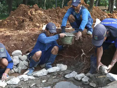 Petugas menyelesaikan pembuatan sumur resapan di kawasan Monas, Jakarta, Selasa (26/2). Pemkot Jakarta Pusat akan membangun 1.000 sumur resapan yang tersebar di berbagai lokasi untuk menampung air hujan. (Liputan6.com/Immanuel Antonius)