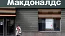 Seorang perempuan berbicara melalui ponsel di depan restoran McDonald's yang tutup di Moskow, Rusia pada 16 Mei 2022. Raksasa makanan cepat saji asal Amerika, McDonald's, akan keluar dari pasar Rusia dan menjual bisnisnya di negara yang semakin terisolasi itu, kata perusahaan tersebut pada Senin kemarin. Banyak bisnis Barat menarik diri dari Rusia sejak invasi pasukan Moskwa ke Ukraina pada Februari. (Kirill KUDRYAVTSEV / AFP)