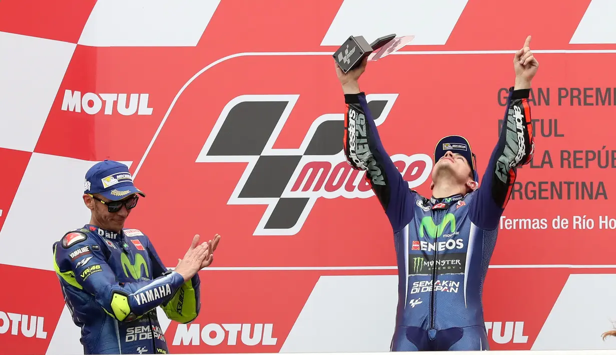 Pembalap Movistar Yamaha Maverick Vinales merayakan kemenangan di atas podium usai menjuarai MotoGP Argentina di Sirkuit Termas de Rio Hondo, Minggu (9/4).Vinales menyelesaikan balapan dengan catatan waktu 41 menit 45,060 detik (AP Photo/Nicolas Aguilera)