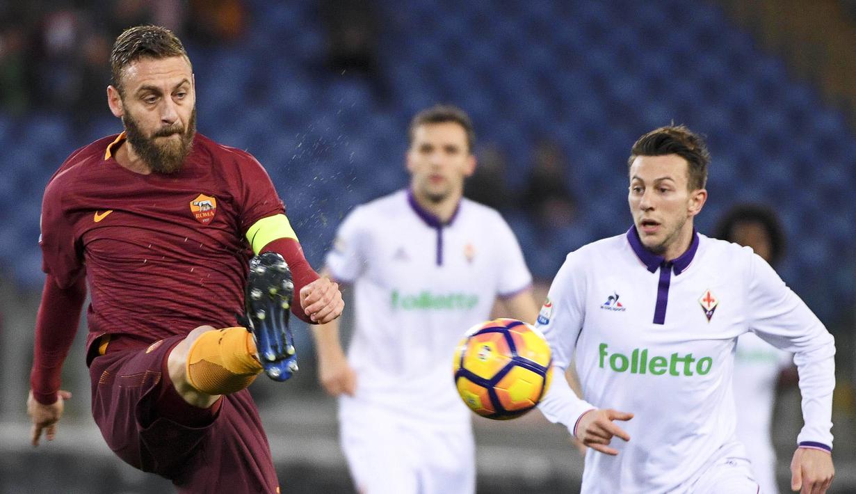 Pemain Roma, Daniele De Rossi (kiri) menghalau bola dari kejaran pemain Fiorentina, Federico Bernardeschi (kanan) pada lanjutan Serie A Italia di  Olimpico stadium, Roma, (7/2/2017). AS Roma menang 4-0. (EPA/Maurizio Brambatti)