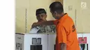 Tahanan memasukkan surat suara ke dalam kotak usai mencoblos di TPS 15 Rutan Polda Metro Jaya, Jakarta, Rabu (17/4). Sebanyak 538 tahanan di Rutan Polda Metro Jaya yang telah terdaftar dalam DPT ikut menyuarakan aspirasinya dalam Pemilu 2019. (Liputan6.com/Herman Zakharia)