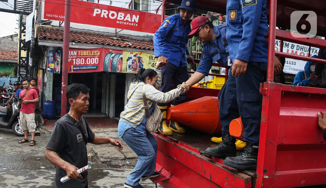 Sejumlah personel petugas gabungan disiagakan untuk membantu warga yang akan melintasi ruas jalan tersebut. (Liputan6.com/Angga Yuniar)