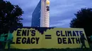 Aktivis organisasi lingkungan Greenpeace membuka spanduk di samping gedung kantor pusat ENI—perusahaan minyak dan gas Italia—di Roma, Selasa, 5 Desember 2023. (AP Photo/Andrew Medichini)