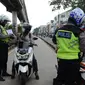 Anggota Satlantas Jakarta Timur merazia sepeda motor yang masuk jalur Transjakarta di kawasan Jatinegara, Jakarta, Kamis (7/2). Pelanggaran ini sering terjadi pada pagi hari. (Merdeka.com/Imam Buhori)