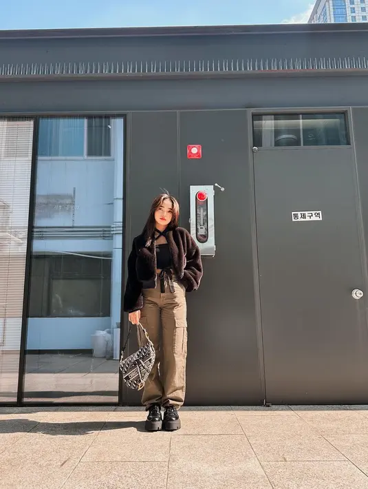 Penampilan manis Fuji dengan atasan hitam, ditumpuknya dengan jaket bulu yang juga berwarna hitam. Semakin sempurna, Fuji memadukan penampilannya dengan cargo pants cokelat dan sneakers hitam. [Foto: Instagram/fuji_an]