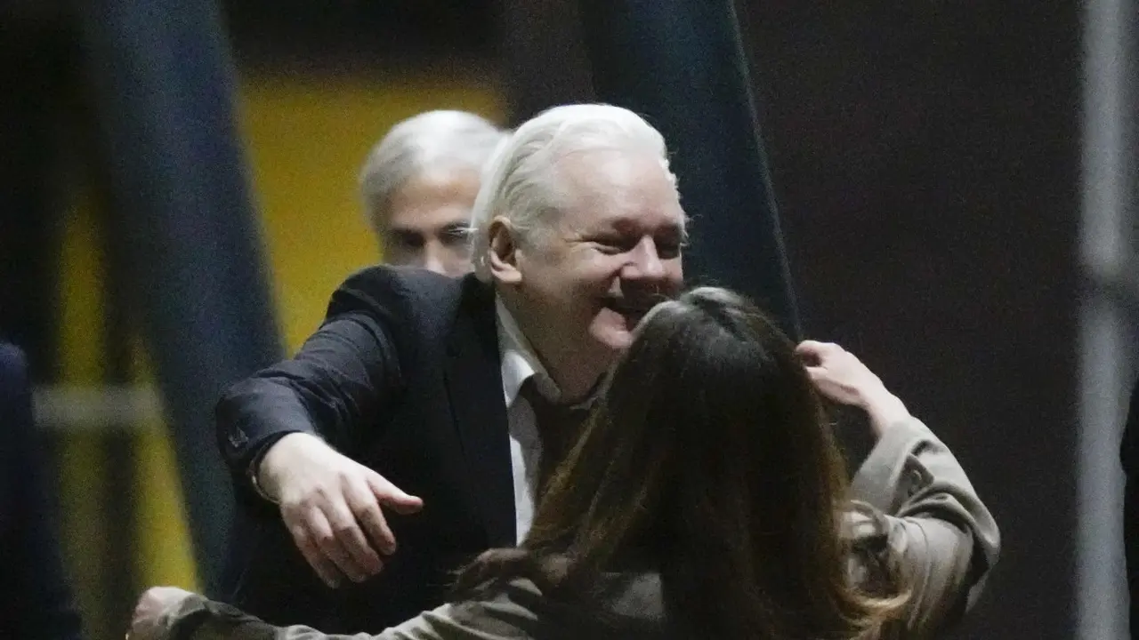 Pendiri Wikileaks Julian Assange setelah mendarat di pangkalan udara RAAF Fairbairn di Canberra, Australia Rabu, 26 Juni 2024 memeluk sang istri.(AP/Rick Rycroft)