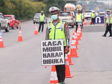 Petugas kepolisian saat melakukan pengecekan SIKM  terhadap kendaran yang akan memasuki  Jakarta di gerbang tol Cikupa, Rabu (27/5/2020). Masyarakat wajib menunjukan SIKM bila ingin kembali atau memasuki Jakarta, Hal tersebut bertujuan untuk menekan penyebaran Covid-19. (Liputan6.com/Angga Yuniar)