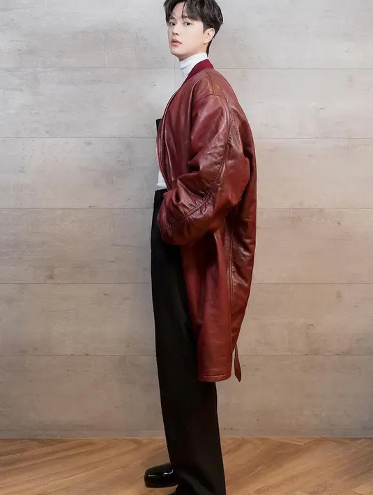 Gaya lain Song Kang pamer kaki jenjang dalam balutan turtleneck putih yang dipadu dengan celana panjang dan sepatu hitam, ditumpuk dengan long leather outer merah. [Foto: Instagram/songkang_b]