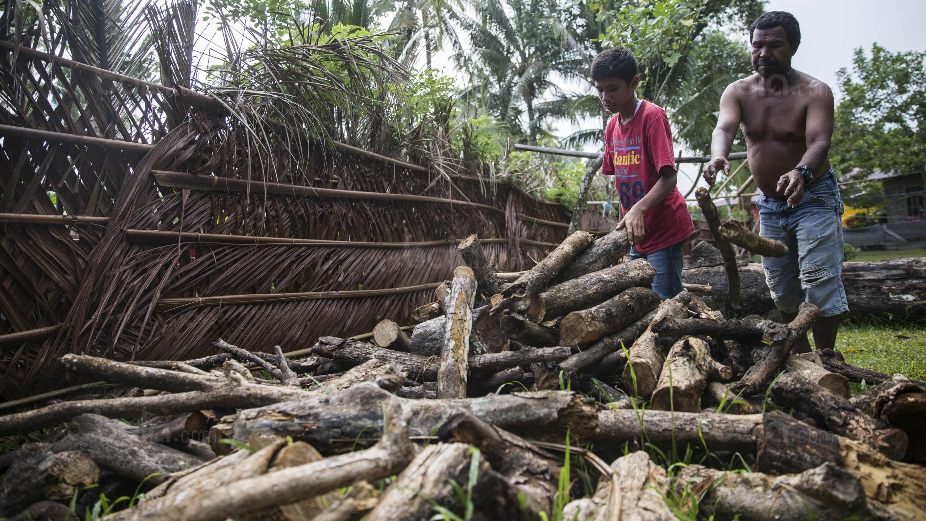 Pesepak bola SSB Tulehu, Rizki Lestaluhu saat membantu ayahnya memilih kayu bakar. (Bola.com/Vitalis Yogi Trisna)