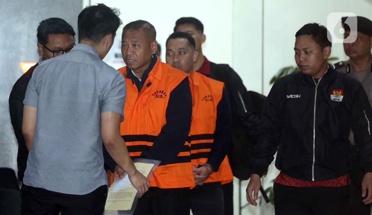 Dalam operasi tersebut, KPK mengamankan 16 orang, termasuk bupati dan sejumlah pejabat Pemerintah Kabupaten Tulungagung. Tampak dalam foto, Bupati Tulungagung, Gatut Sunu Wibowo (kedua kiri) dibawa petugas menuju mobil tahahan usai menjalani pemeriksaan intensif di Gedung Merah Putih Komisi Pemberantasan Korupsi (KPK), Jakarta, Minggu (12/4/2026) dini hari WIB. (Liputan6.com/Helmi Fitrhiansyah)