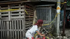 Sebuah stiker peringatan bertuliskan “Bahaya Radiasi” dengan catatan tulisan tangan yang menunjukkan “11,5 mikrosievert per jam” terlihat di salah satu tiang listrik di samping Kawasan Industri Modern Cikande, tempat isotop radioaktif Cesium-137  terdeteksi, di Sukatani, Banten pada 13 Oktober 2025. (Yasuyoshi CHIBA/AFP)