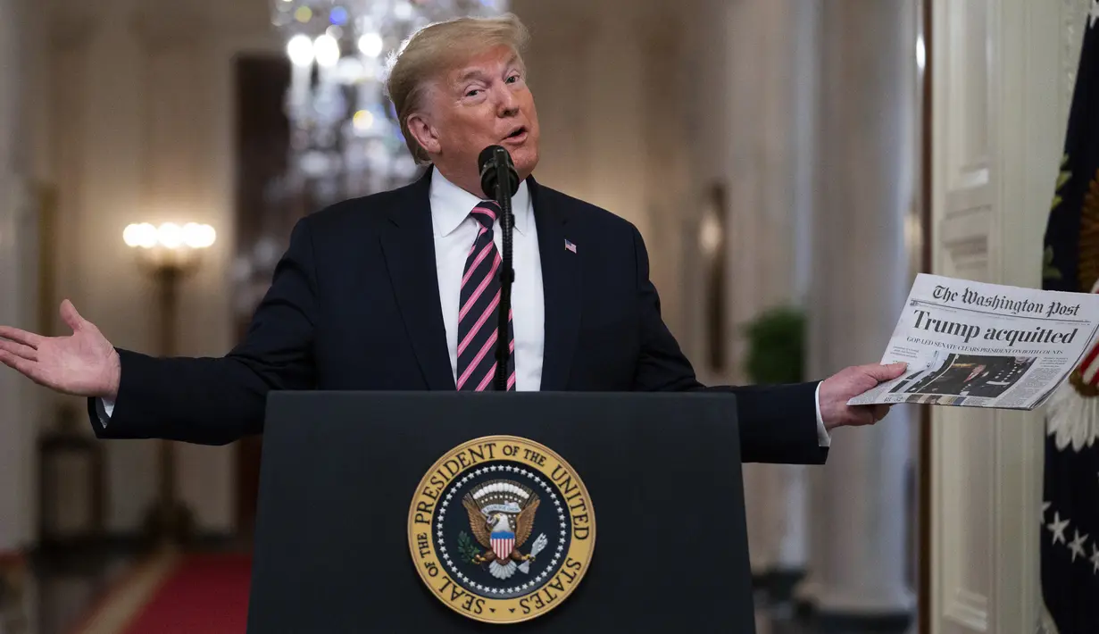 Presiden Donald Trump mengangkat sebuah surat kabar dengan tajuk utama bertuliskan "Trump dibebaskan" selama acara perayaan kemenangan, satu hari setelah upaya pemakzulannya dibatalkan di Ruang Timur Gedung Putih, Washington (6/2/2020). (AP Photo/Evan Vucci)