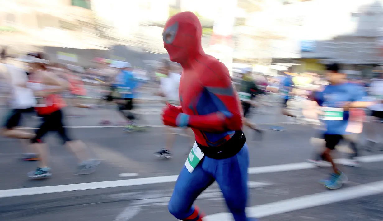 Salah satu peserta mengenakan kostum Spiderman saat berpartisipasi dalam lomba lari City2Surf Fun di Sydney, Australia, Minggu (13/8). Lomba ini merupakan acara lari santai tahunan dengan rute sepanjang 14 kilometer. (AP Photo/Rick Rycroft)