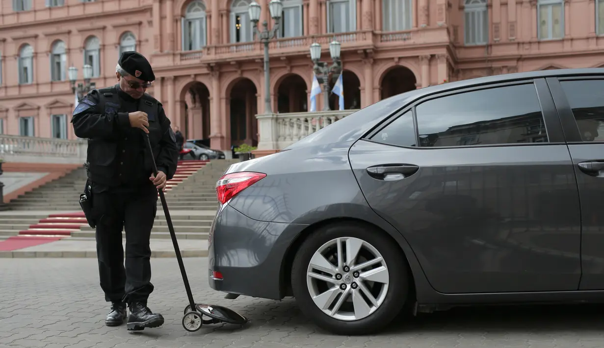 Seorang petugas polisi memeriksa sebuah mobil di depan Istana Kepresidenan di Buenos Aires, Argentina, Kamis (29/11). Pemerintah Argentina memperketat keamanan jelang digelarnya KTT G20. (AP Photo/Sebastian Pani)