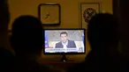 Wartawan menyaksikan pidato Perdana Menteri Yunani Alexis Tsipras di televisi di Athena, Kamis (20/8/2015). Dia mengumumkan pengunduran dirinya dan menyerukan pemilu dini tanggal 20 September. (AFP PHOTO/LOUISA GOULIAMAKI)