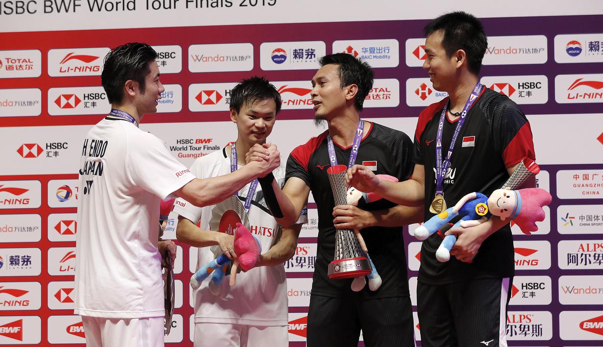 Ganda putra Indonesia  Mohammad Ahsan/Hendra Setiawan bersalaman dengan Hiroyuki Endo/Yuta Watanabe dari Jepang usai meraih juara BWF World Tour Finals 2019 di Tianhe Gymnasium, Guangzhou (15/12/2019).  Ahsan/Hendra menang  24-22, 21-19.  (AP Photo/Andy Wong)