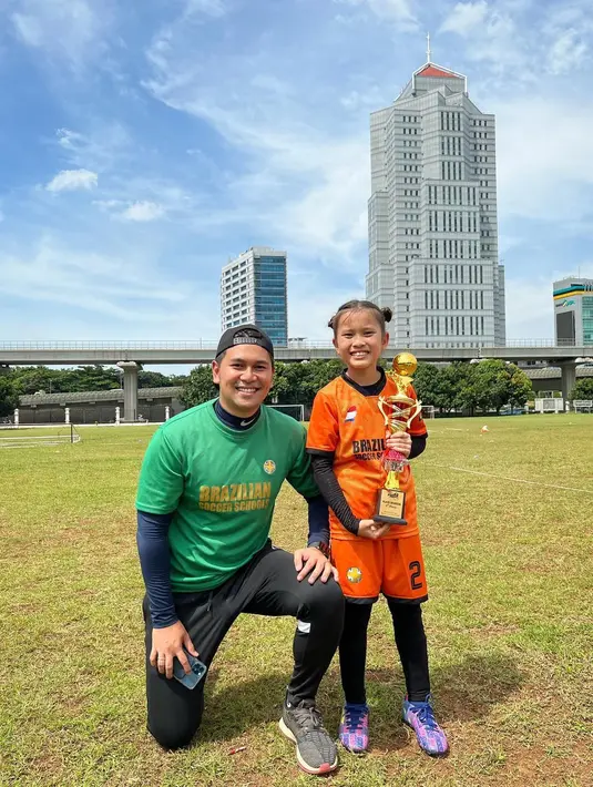 Zaskia Adya Mecca mengunggah sejumlah foto Kala Madali mengenakan seragam sepak bola oranye, menggiring dan mengoper bola ke rekan setim, di akun Instagram terverifikasi, Jumat (4/11/2022). Salah satu foto memperlihatkan Kala Madali berdiri memegang piala didampingi pelatih dalam pose jongkok berkaus hijau. Keduanya tampak semringah. Selamat! (Foto: Dok. Instagram @zaskiadyamecca)