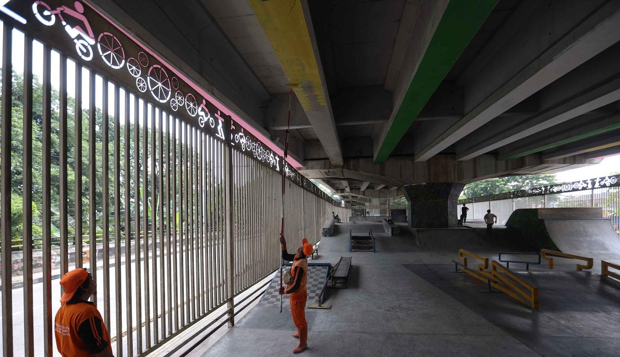 Selain arena tinju, terdapat juga fasilitas skatepark berstandar internasional yang dapat digunakan secara gratis. Tampak dalam foto, petugas Penanganan Prasarana dan Sarana Umum (PPSU) melakukan pengecatan di kolong jembatan layang Pasar Rebo, Jakarta Timur, Jumat (8/5/2026). (Kapanlagi.com/Budy Santoso)