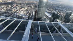 Sepasang pengunjung menikmati kebersamaan bermain ice skating di arena ski lantai teratas pusat bisnis Oko Tower di Moskow, Kamis (15/12). Arena ski yang berada di ketinggian 354 meter ini diklaim menjadi yang tertinggi di Eropa. (REUTERS/Maxim Shemetov)