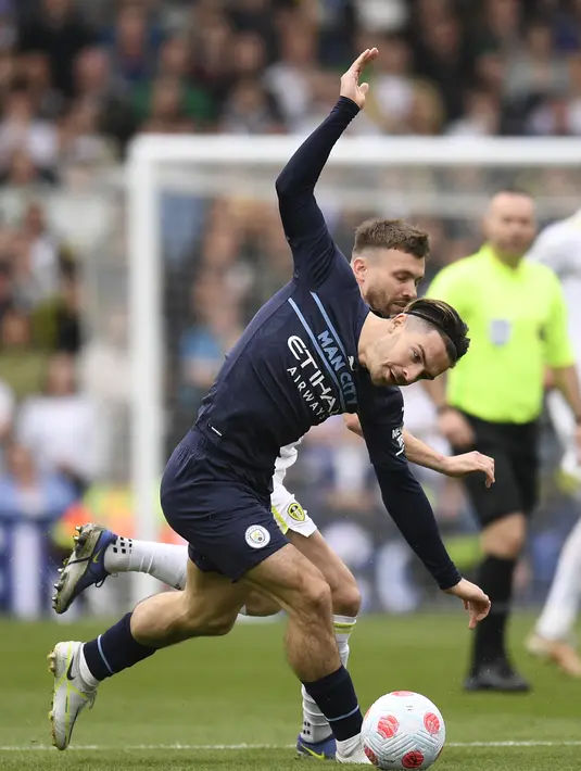 <p>Gelandang Leeds United, Stuart Dallas (belakang) bersaing dengan gelandang Manchester City, Jack Grealish pada pertandingan lanjutan Liga Inggris di Elland Road di Leeds, Inggris utara (30/4/2022). Man City kembali ke puncak klasemen berkat keunggulan satu poin atas Liverpool. (AFP/Oli Scarff)</p>